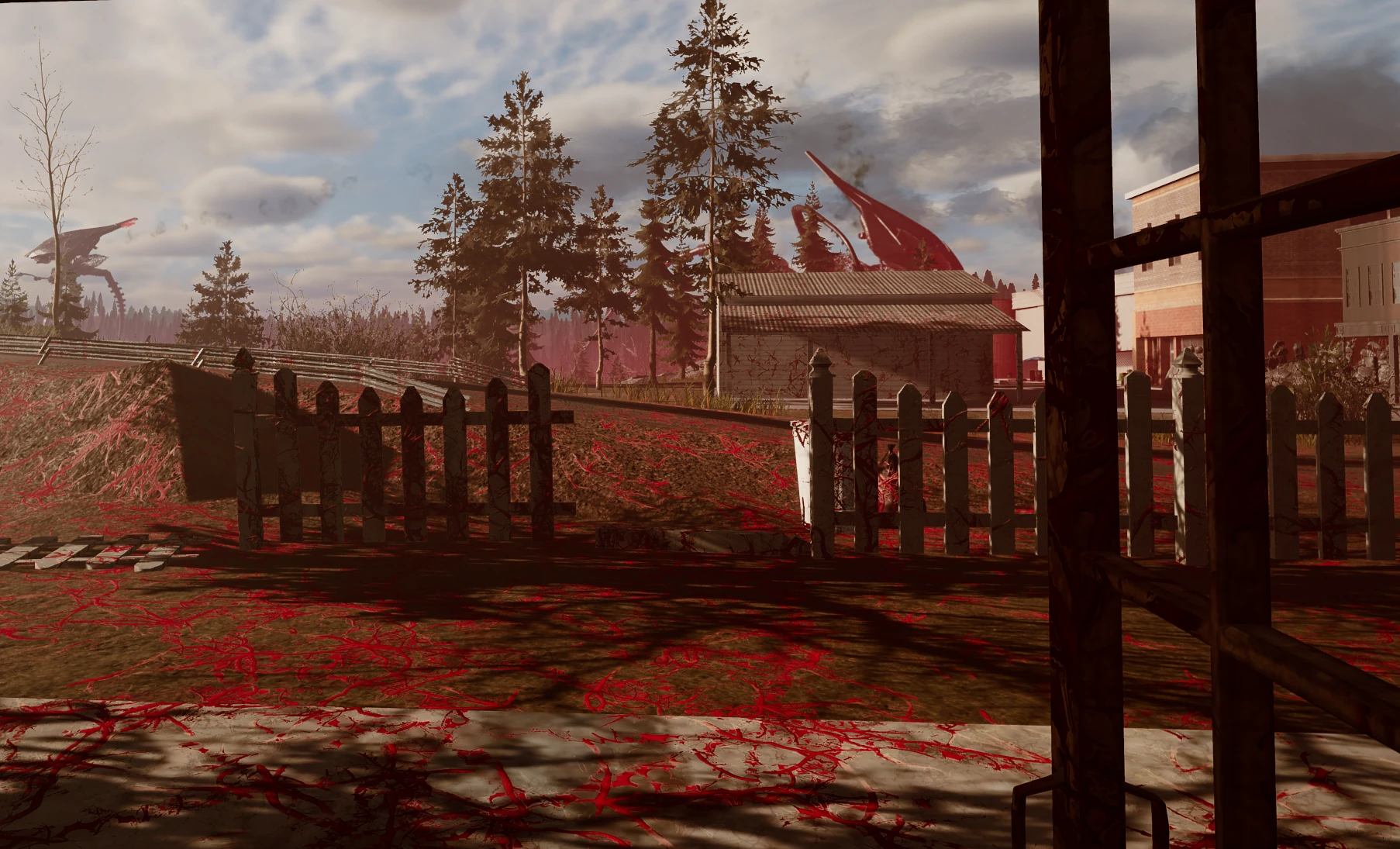 Red weed spreads across a yard and picket fence as two tripods loom over the trees beyond.